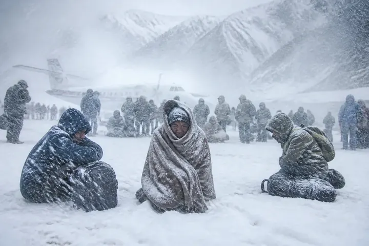 blizzard meaning picture: Travellers huddled at a snowed-in mountain airport in the Himalayas during a fierce snowstorm